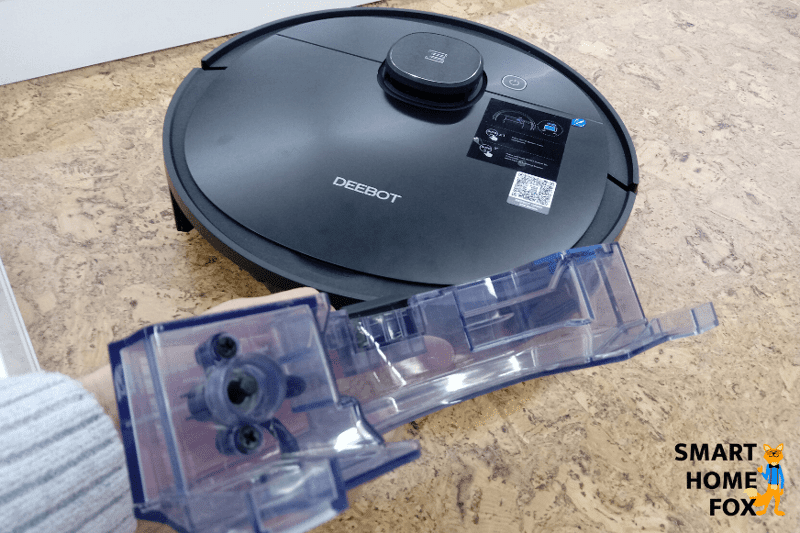 Man sieht die Unterseite eines Saug- Wischroboters mit Wischmopp und der Reinigungsbürste.